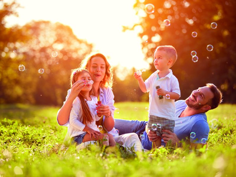 Family with children blow soap bubbles outdoor